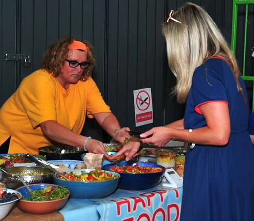 Vendor serving customer fresh food at a market stall